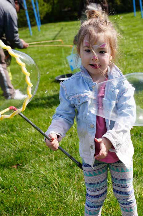 Little girl playing with bubbles outside