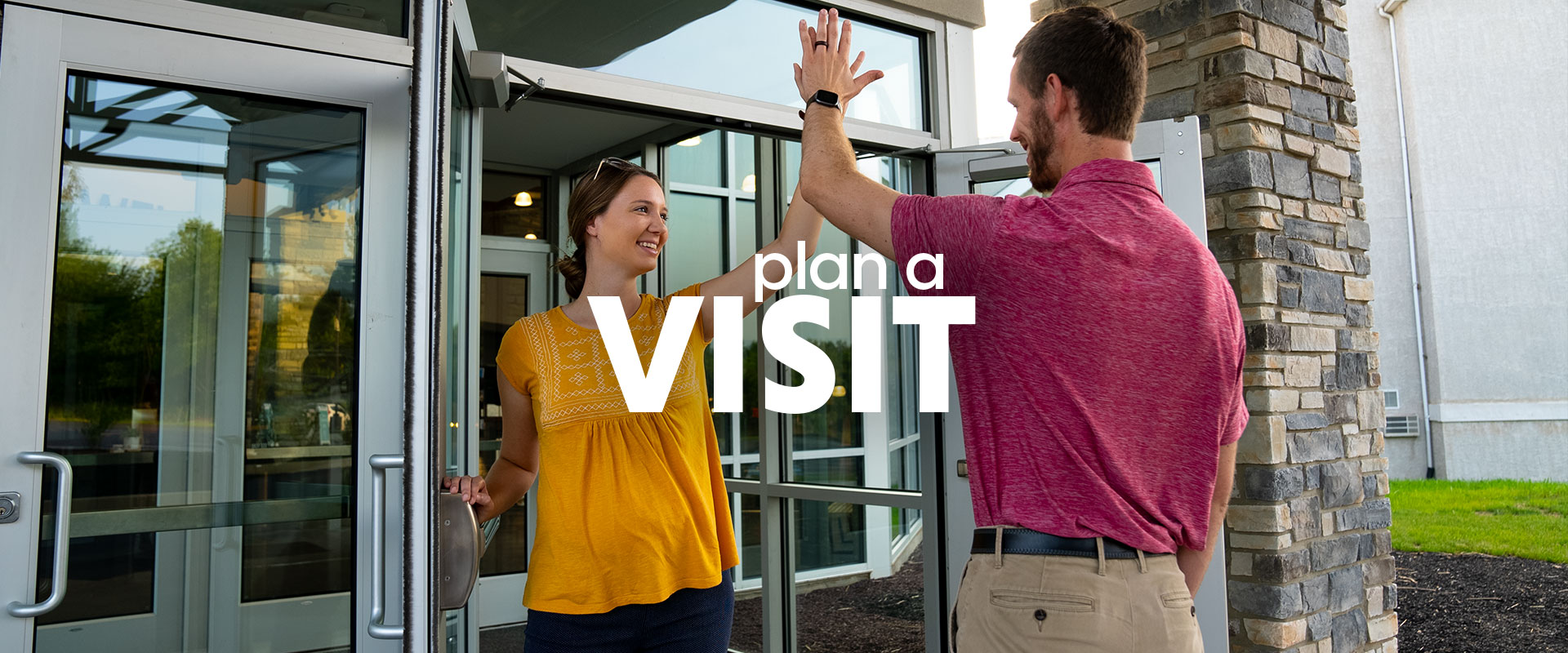 Greeters giving a high five to visitors